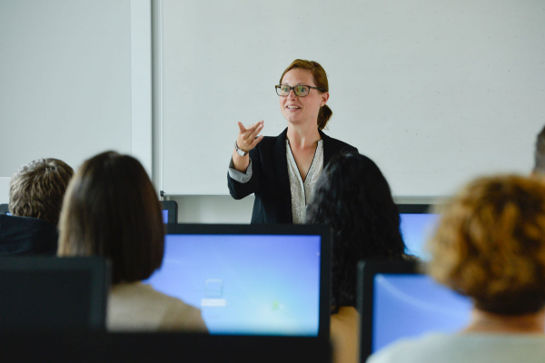 Professorin doziert vor Student/innen im Hörsaal