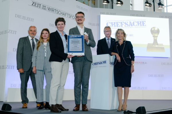 Sechs Personen stehen auf dem Podium und zeigen die Urkunde zur Preisverleihung Chefsache Award 2017