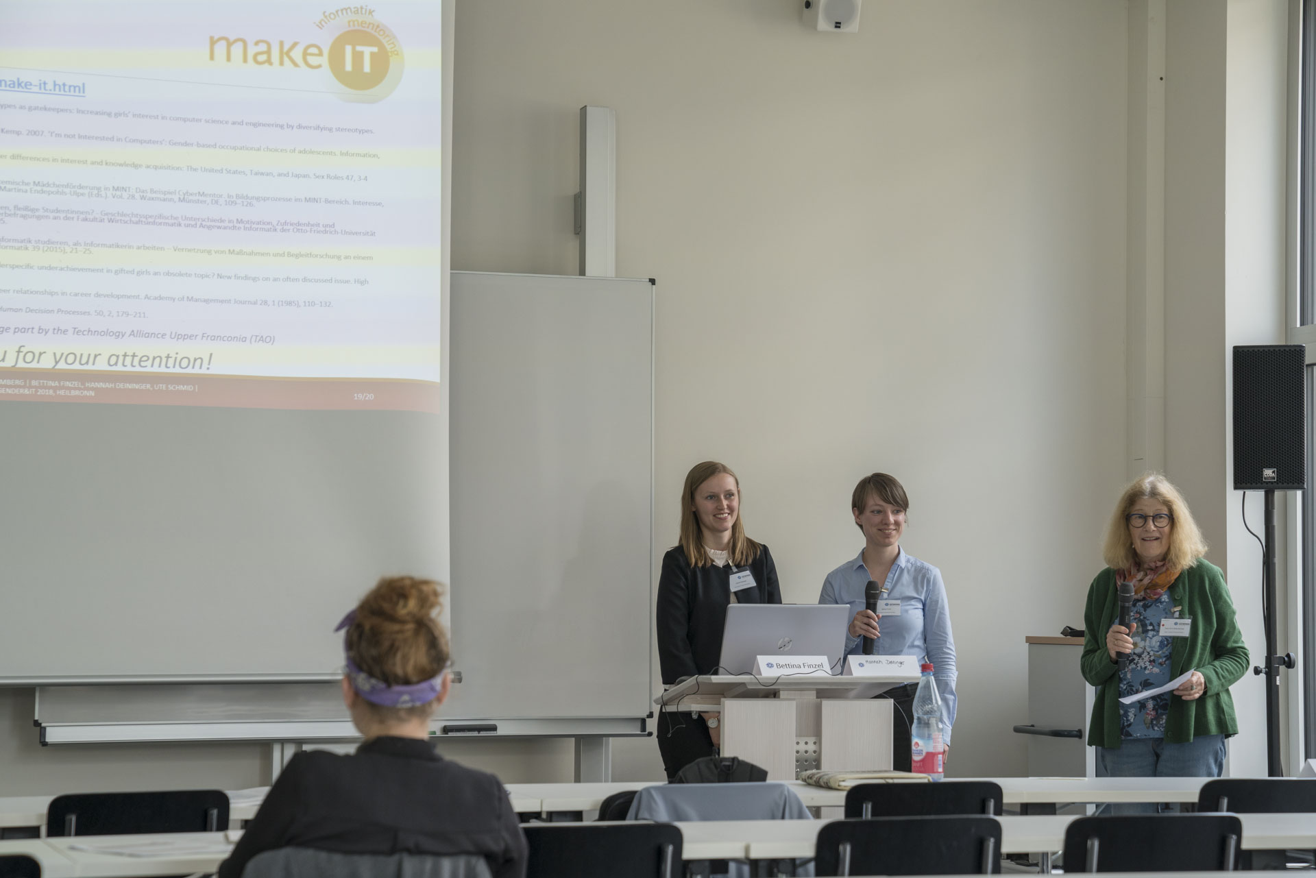 Drei Frauen stehen am Rednerpult und halten ihren Vortrag