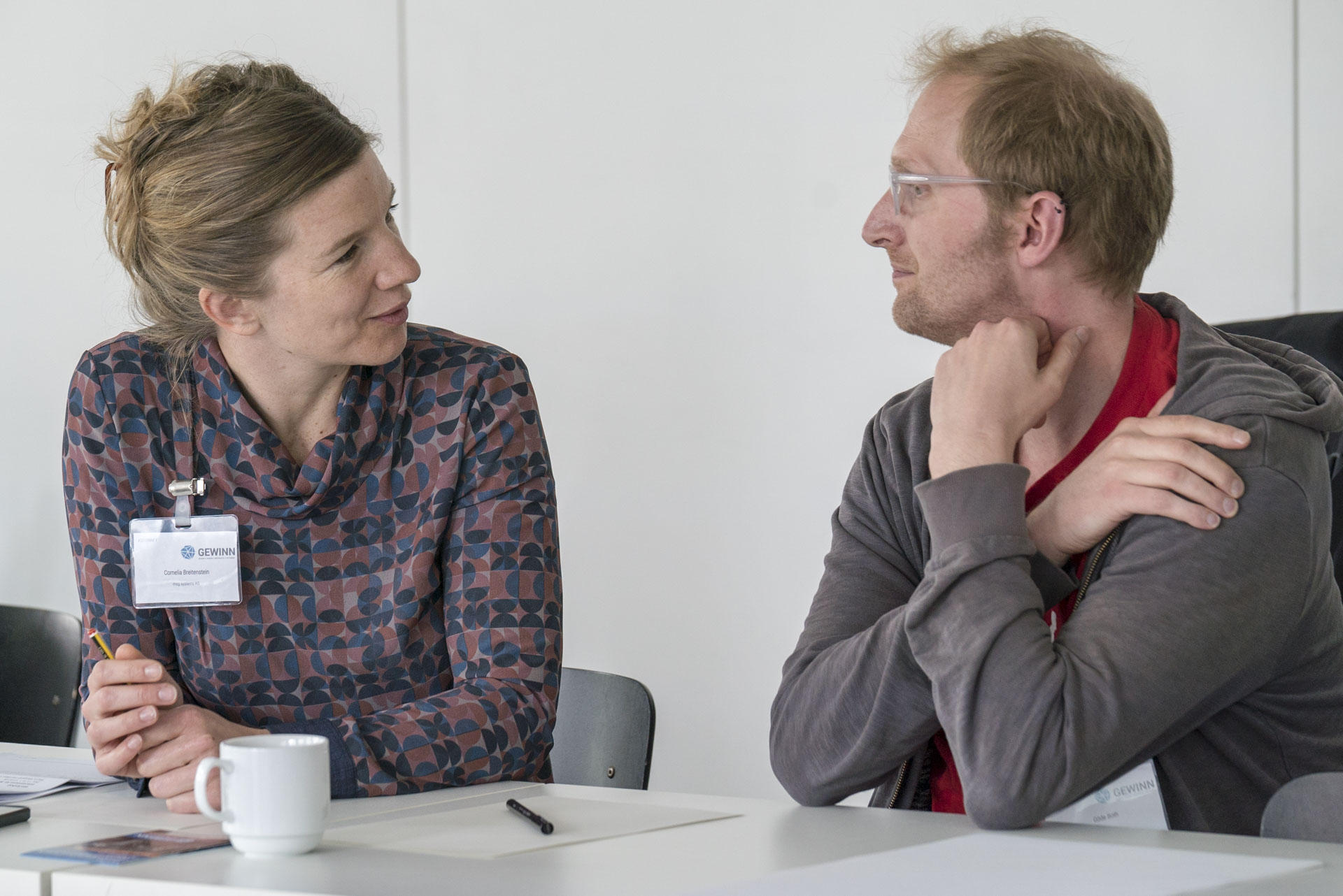 Zwei Teilnehmer/innen im Gespräch am Tisch sitzend