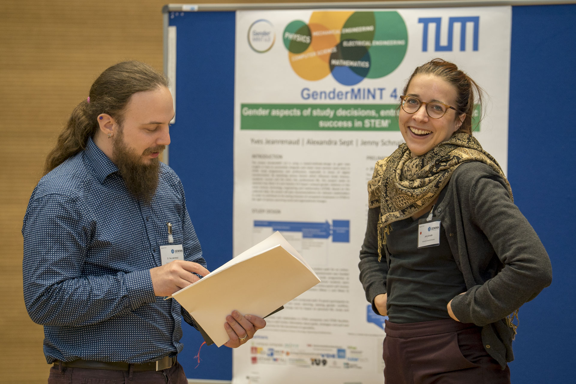 Teilnehmer/innen im Gespräch vor Plakat