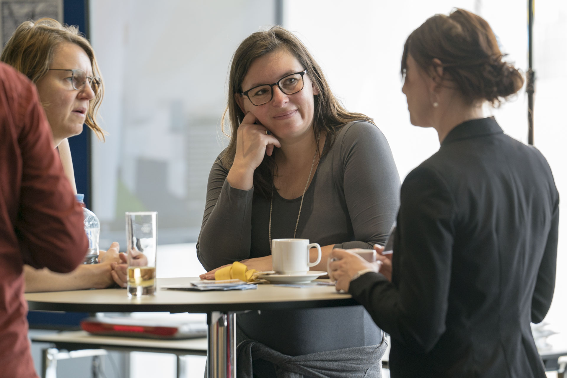 Drei Frauen am Stehtisch im Gespräch