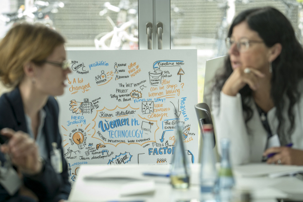 Zwei Frauen im Gespräch, sitzend am Tisch